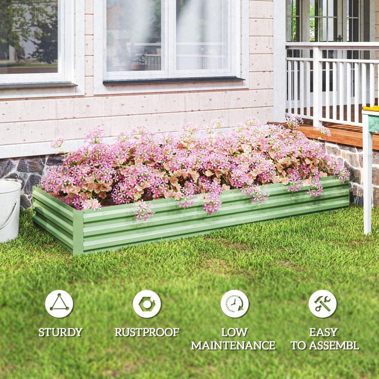 Light green galvanized raised garden bed with pink and white flowers in outdoor yard