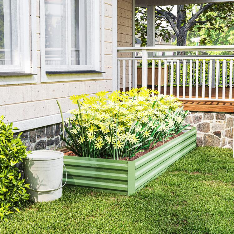 Light green galvanized raised garden bed with yellow flowers and leafy plants