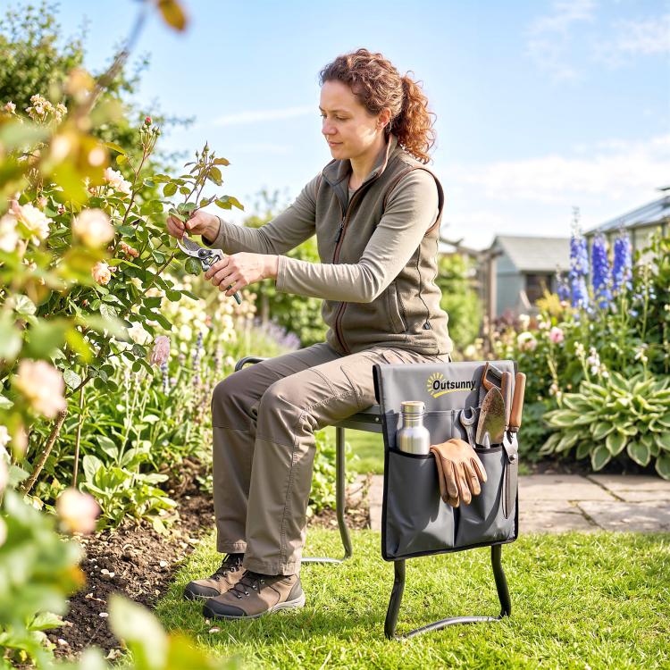 Gray garden seat with tool pouch and padded top on metal frame, gardener tending plants.