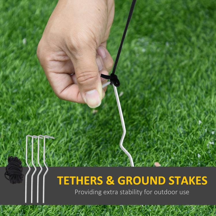 Outdoor inflatable tethers and ground stakes with hand securing line on green grass