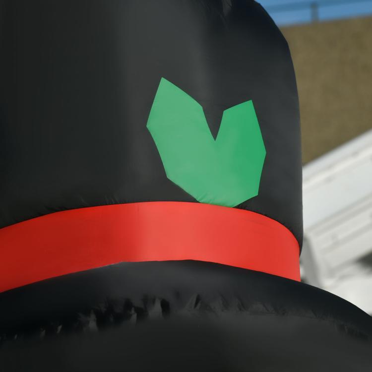 Close-up of inflatable top hat and red band with green leaf emblem on snowman