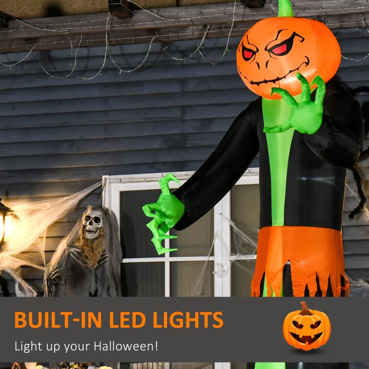 Inflatable pumpkin-head ghost with green hands, black robe, and orange pumpkin head