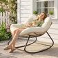 Cream cushioned papasan rocking chair with woven base and black rockers outdoors