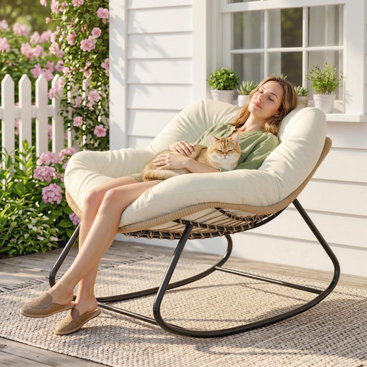 Cream cushioned papasan rocking chair with woven base and black rockers outdoors