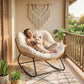 Cream cushioned rocking chair with woven rattan sides and black metal rockers on porch