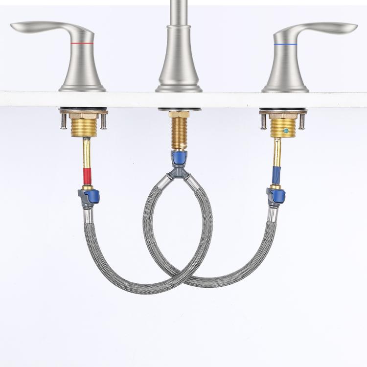 Brushed nickel faucet with supply hoses and 3-hole handles, close-up view