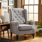 Gray wingback reading chair with button-tufted back, rolled arms, and dark turned legs.