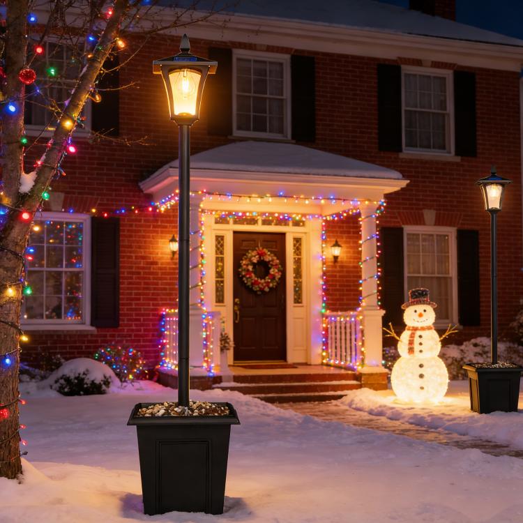 Outdoor black solar lantern post light standing in snow near a doorway and lights