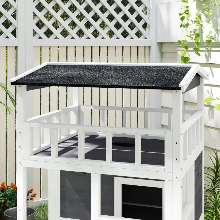 Outdoor wooden cat house with dark gray asphalt roof, front entry doors and platforms
