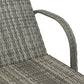 Curved woven rattan arm and backrest of a gray cushioned outdoor chaise lounge