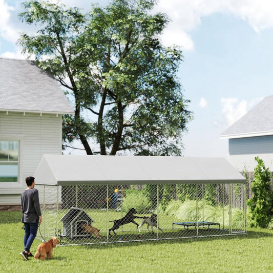 Outdoor chain-link dog kennel with waterproof roof; dogs inside in backyard