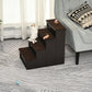 Brown cushioned pet stairs with four steps and dark frame, two cats nearby
