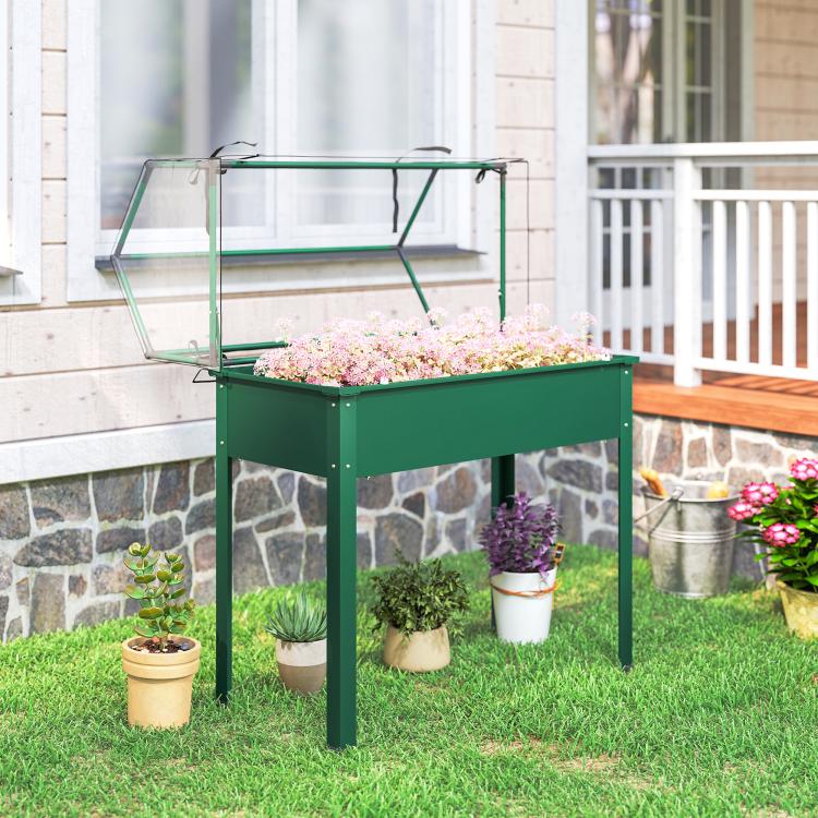 Green raised garden bed with greenhouse cover and four legs, with potted flowers