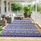 Reversible outdoor rug with blue-and-white geometric pattern, spread on patio