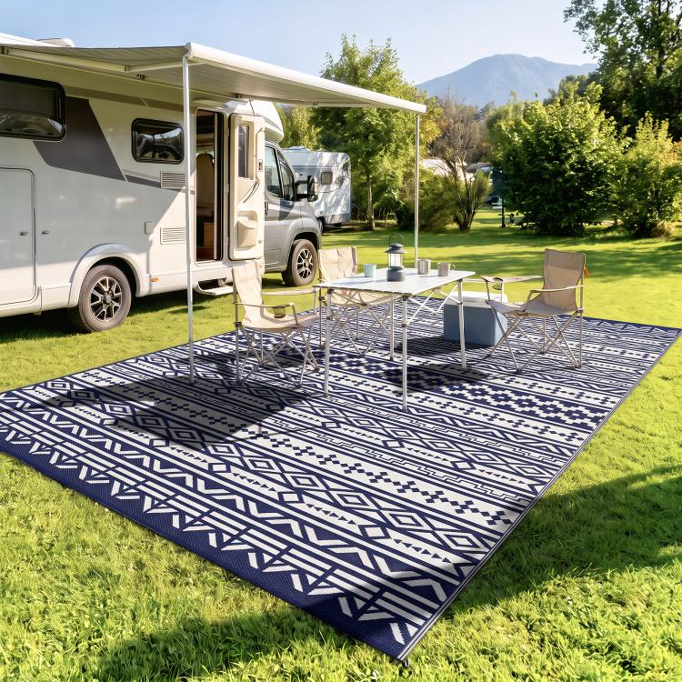 Reversible outdoor rug with blue-and-white geometric pattern, under outdoor dining set