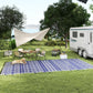 Reversible outdoor rug with blue-and-white geometric pattern, laid for camping