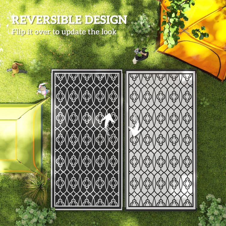 Reversible rug showing two sides: black and white clover trellis pattern