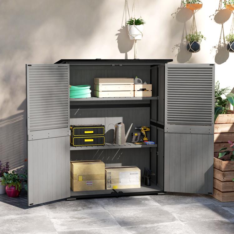 Gray outdoor wooden shed with double doors open and storage shelves inside