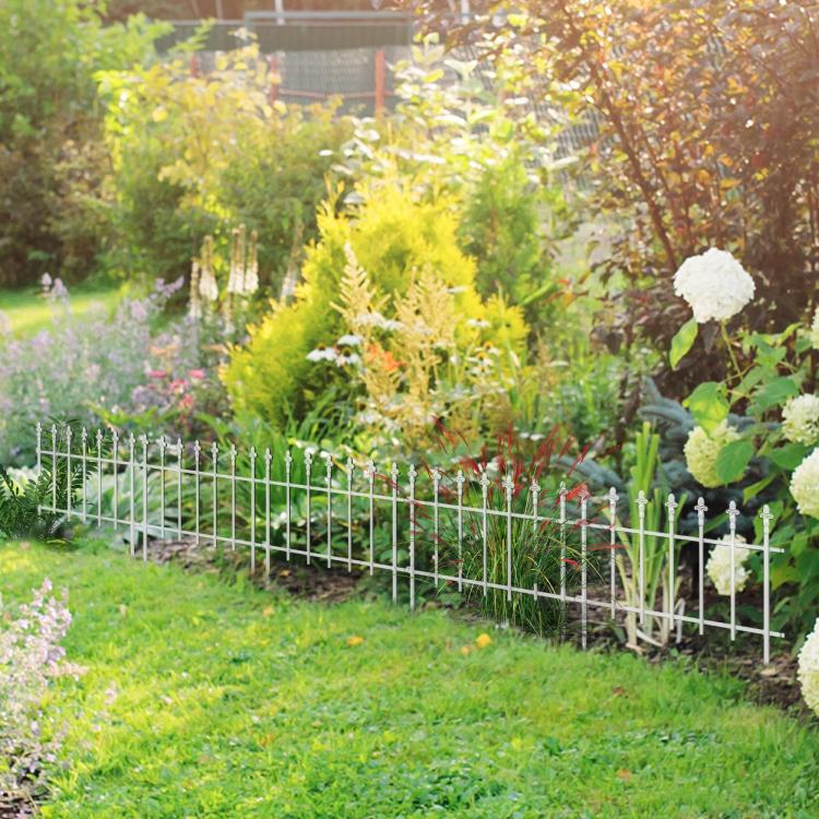 White metal garden border fence around a flower bed with a curved corner