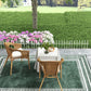 White metal garden fence border with chairs, flowers, and a patio walkway