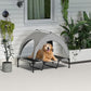 Canopy raised dog bed with gray frame and black mesh, dog sitting in shaded shelter