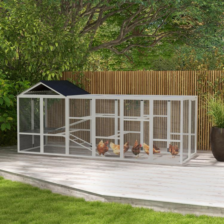 Gray chicken coop run with black roof, wire mesh sides and perches inside