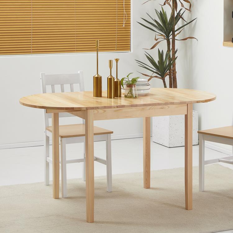 Natural wood drop-leaf dining table with a vase centerpiece and two chairs