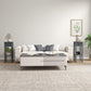 Gray side table with drawer and lower shelf, styled beside a sofa.