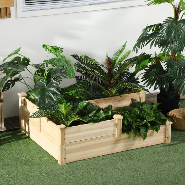 Three-tier raised wooden planter box holding green plants on an indoor floor