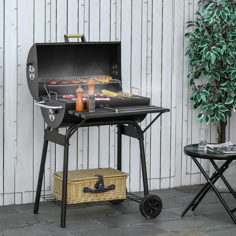 Charcoal barbecue grill with open lid, side shelf, and lower storage rack