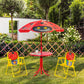 Ladybug red umbrella and round table with two yellow folding chairs on garden lawn