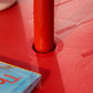 Close-up of red umbrella pole base on a textured round table top