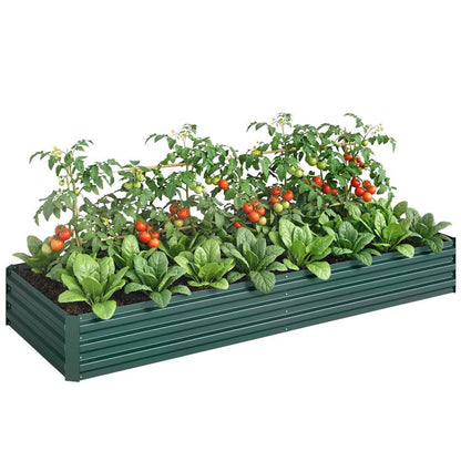 Green galvanized raised garden bed filled with leafy greens and red tomato plants