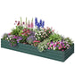 Green raised garden bed planted with mixed colorful flowers and blooming plants