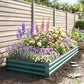Green galvanized raised garden bed filled with colorful flowers and herbs in soil
