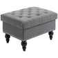 Gray storage ottoman with tufted seat, studded side trim, and turned wooden legs