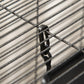 Close-up of black latch and wire bars on a small pet enclosure door