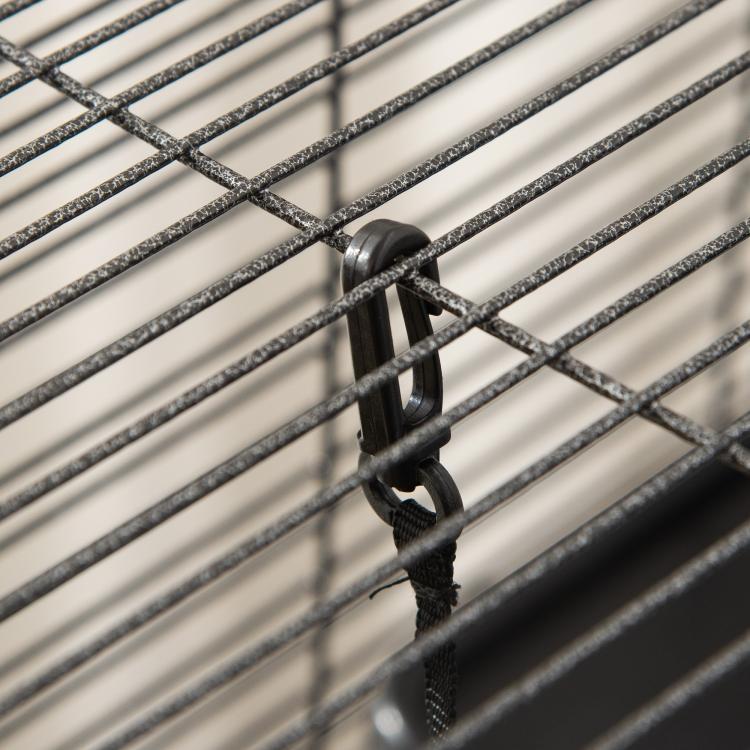 Close-up of black latch and wire bars on a small pet enclosure door