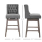 Gray bar stools set with button-tufted backs, padded seats, and wood legs with footrests