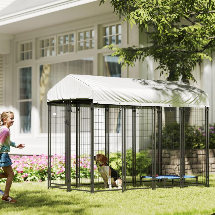 Outdoor dog kennel with roof, black wire pen with dog inside in backyard