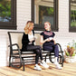 Outdoor glider bench with beige cushions and dark steel frame; two people seated