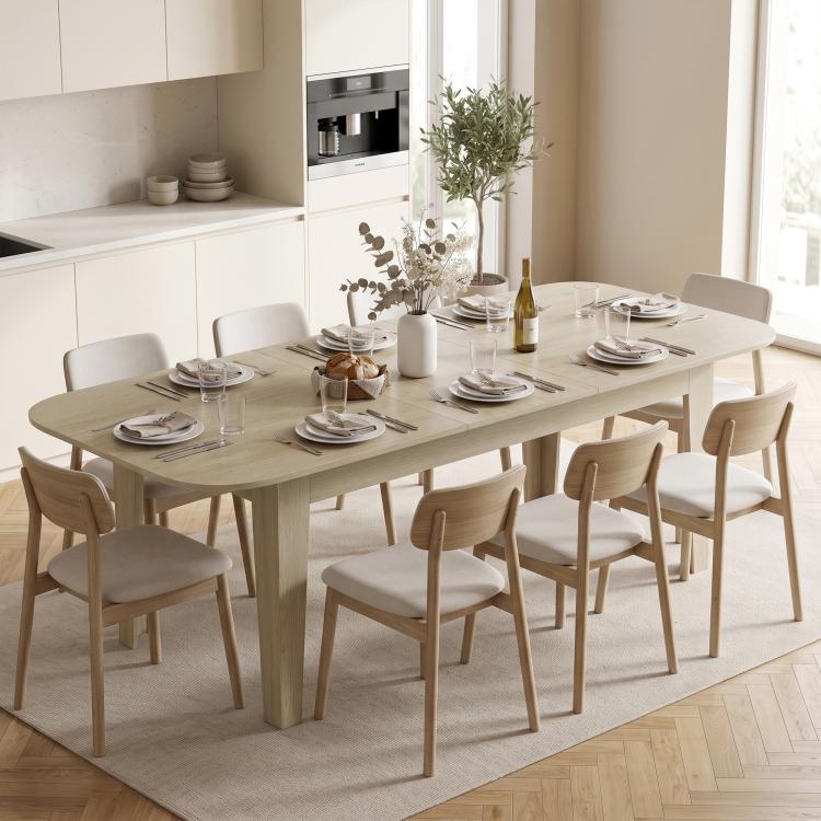 Light oak oval dining table with chairs arranged around the tabletop surface