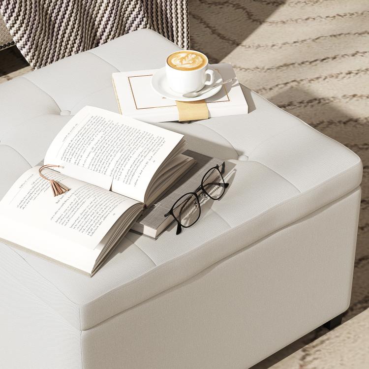 Beige storage ottoman with flip-top lid and padded seat, squared silhouette