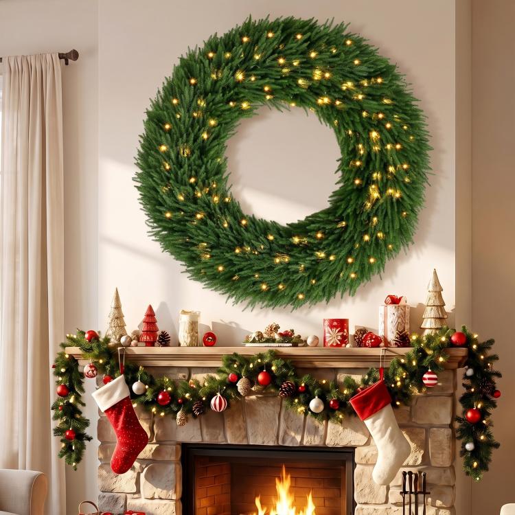 Green artificial wreath with warm white LED lights, hanging over a fireplace