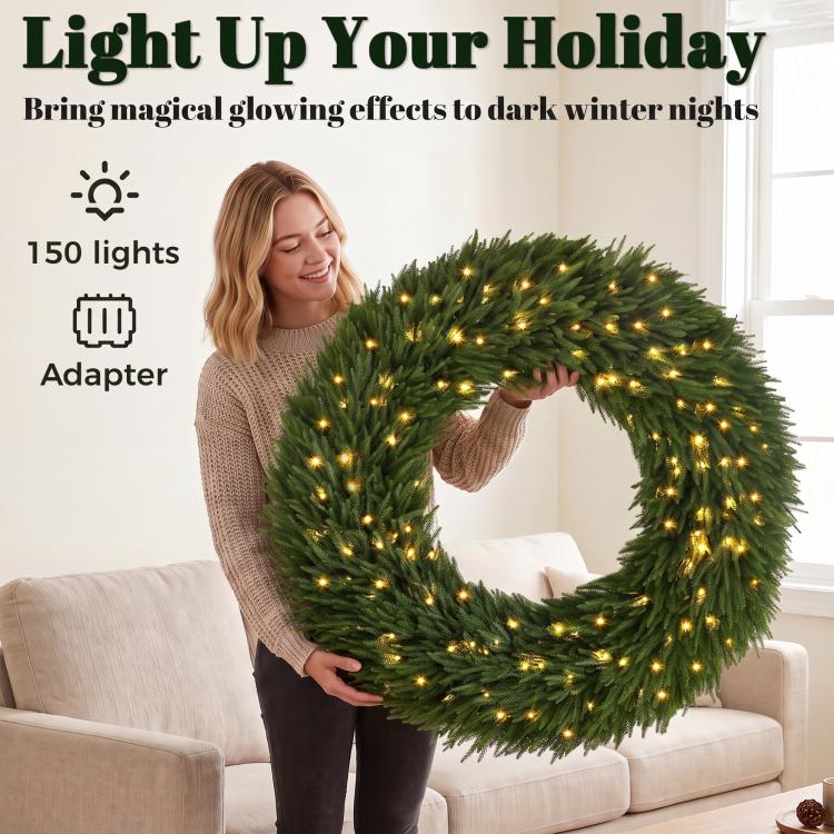 Green pre-lit Christmas wreath with warm white LED lights, held in hands