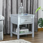 Light gray end table with drawer and lower shelf, with vase and books on top