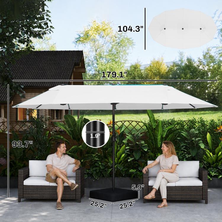 Beige patio umbrella open with central pole and weighted base, over patio seating