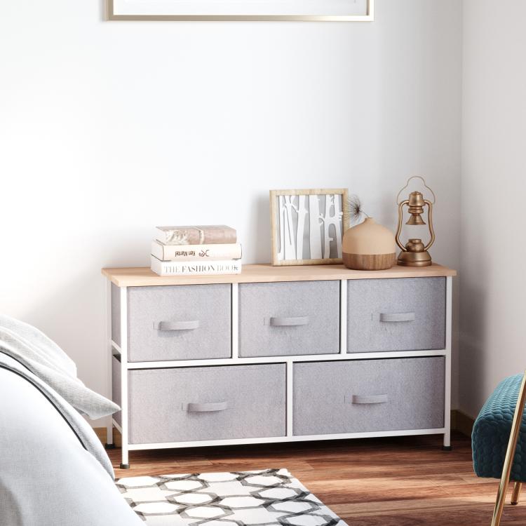 Light gray storage dresser with 5 fabric drawers and wood top, white frame.
