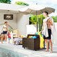 Rattan storage organizer with wheels holding pool floats on a patio near a pool