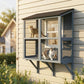Gray outdoor window cat enclosure mounted on house siding with cats on platforms